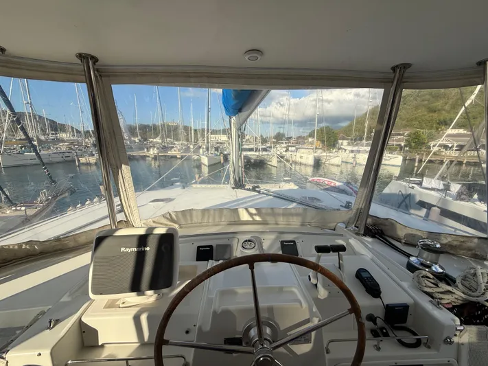 Carolina Breeze Yacht Photos Pics Cockpit view of 2009 Lagoon 500 yacht docked in a marina, featuring steering wheel and navigation equipment.