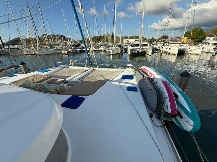 Carolina Breeze Yacht Photos Pics Lagoon 500 catamaran docked in marina, featuring paddleboards and scenic background.