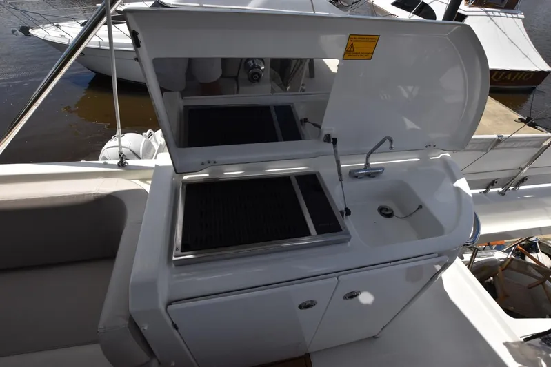  Yacht Photos Pics Outdoor kitchenette on 2019 Beneteau Swift Trawler 44, featuring grill and sink.