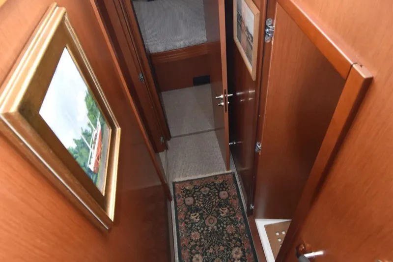  Yacht Photos Pics Interior hallway of 2019 Beneteau Swift Trawler 44 with wood paneling and artwork.