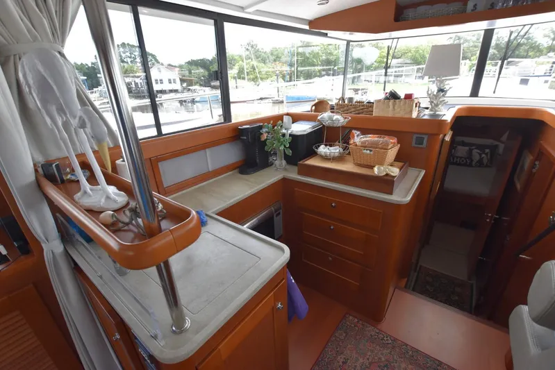  Yacht Photos Pics Interior of 2019 Beneteau Swift Trawler 44, featuring a compact kitchen with wooden cabinetry.