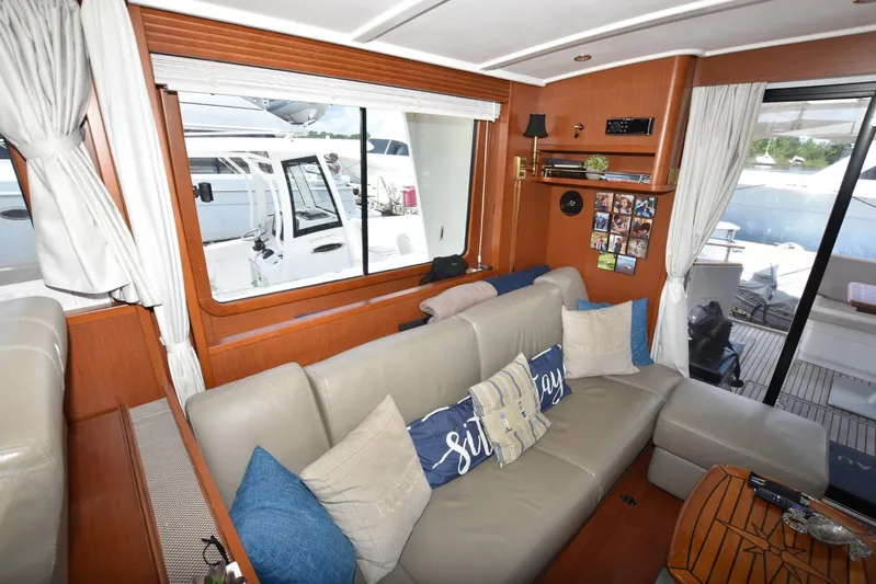  Yacht Photos Pics Interior of 2019 Beneteau Swift Trawler 44 with beige sofa and nautical decor.
