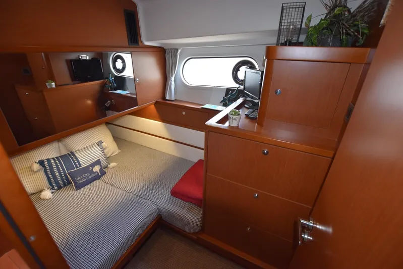  Yacht Photos Pics Cozy cabin interior of 2019 Beneteau Swift Trawler 44 with wooden furnishings and porthole window.