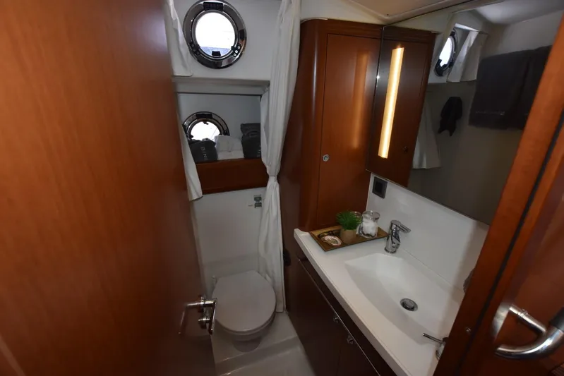  Yacht Photos Pics Bathroom interior of 2019 Beneteau Swift Trawler 44 with modern fixtures and porthole windows.