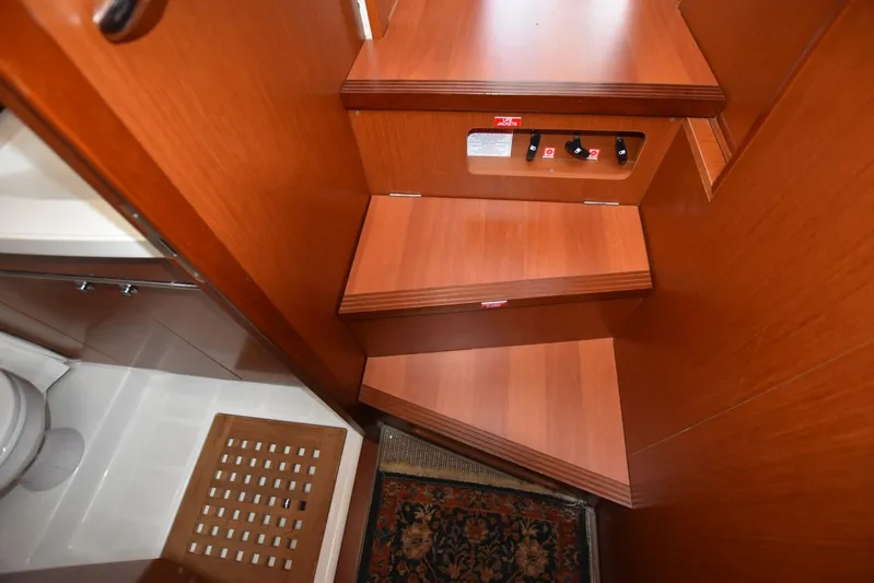  Yacht Photos Pics Interior stairs of 2019 Beneteau Swift Trawler 44, featuring wooden steps and adjacent bathroom.