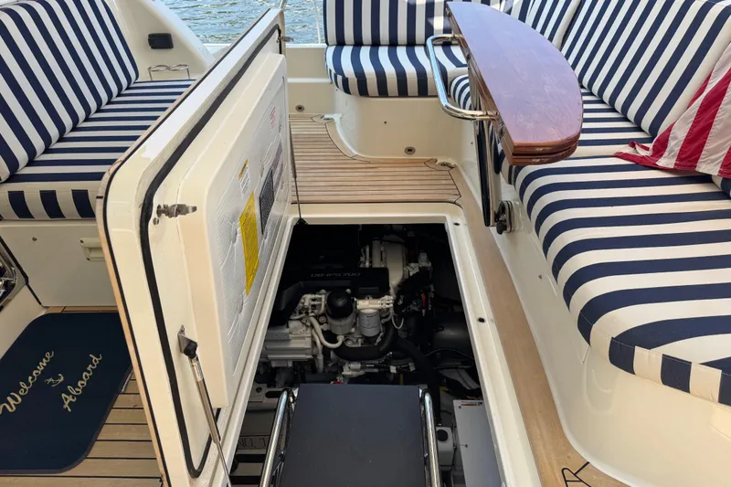 Moving On Yacht Photos Pics 2022 Sabre 48 Salon Express yacht interior with striped seating and open engine compartment.