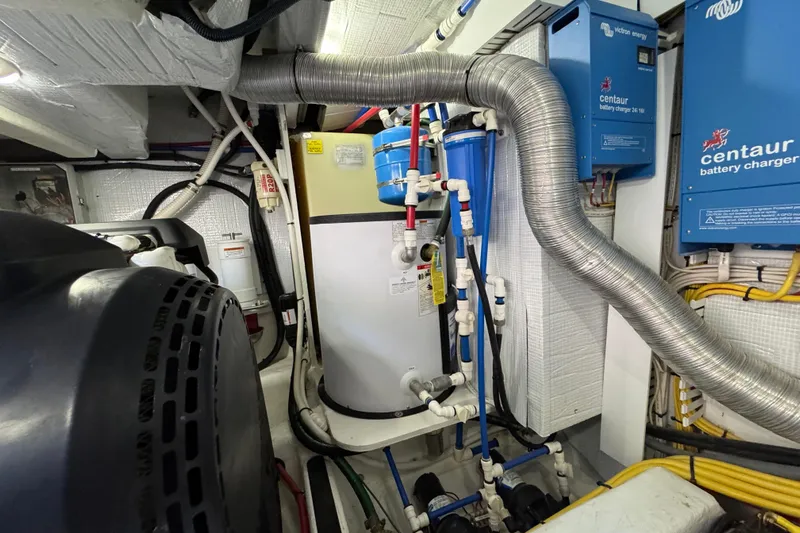 Moving On Yacht Photos Pics Engine room of 2022 Sabre 48 Salon Express with battery chargers and piping.