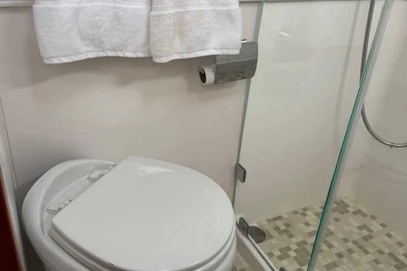 Moving On Yacht Photos Pics Bathroom interior of 2022 Sabre 48 Salon Express yacht, featuring toilet and shower.