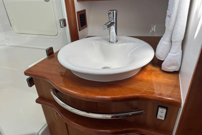 Moving On Yacht Photos Pics Luxurious bathroom sink in 2022 Sabre 48 Salon Express yacht, featuring elegant wood finish.