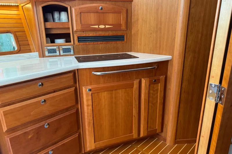 Moving On Yacht Photos Pics 2022 Sabre 48 Salon Express kitchen with wooden cabinetry and modern appliances.