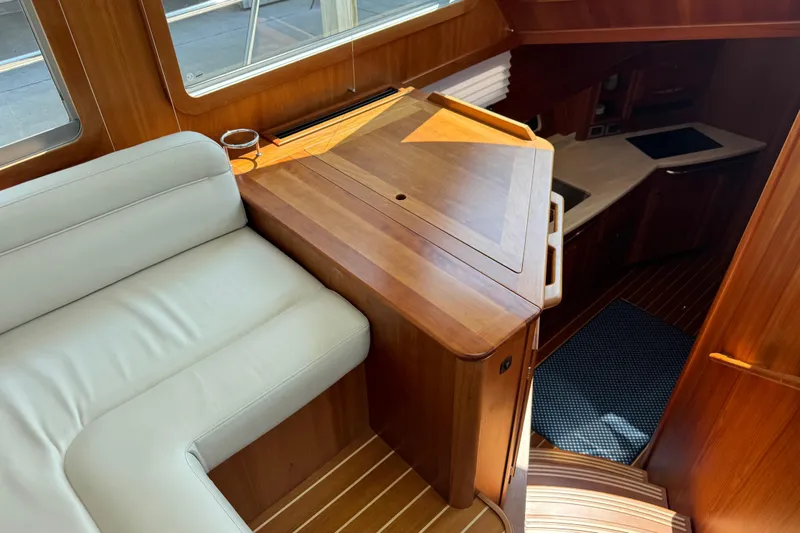 Moving On Yacht Photos Pics Interior of 2022 Sabre 48 Salon Express yacht with wooden cabinetry and white seating.