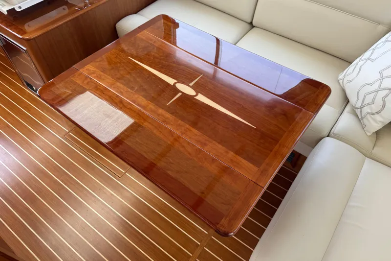 Moving On Yacht Photos Pics Luxurious interior of 2022 Sabre 48 Salon Express with elegant wooden table and seating.