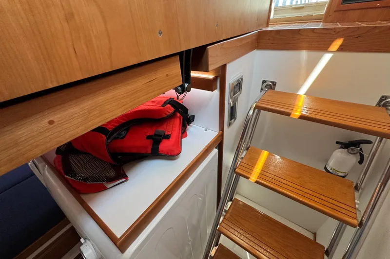 Moving On Yacht Photos Pics Interior of 2022 Sabre 48 Salon Express with wooden stairs and safety equipment.