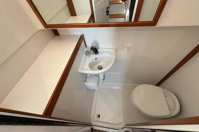 Moving On Yacht Photos Pics Compact bathroom in 2022 Sabre 48 Salon Express yacht, featuring sink and toilet.