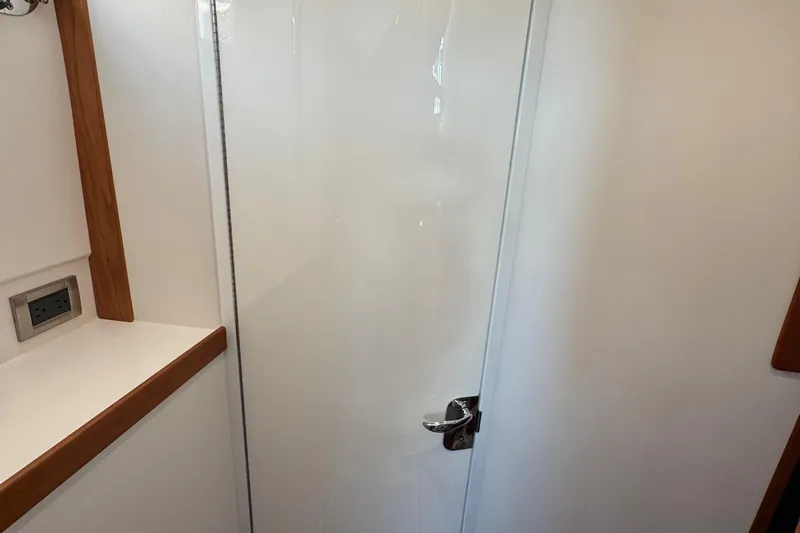 Moving On Yacht Photos Pics 2022 Sabre 48 Salon Express interior with sleek white door and wooden trim.