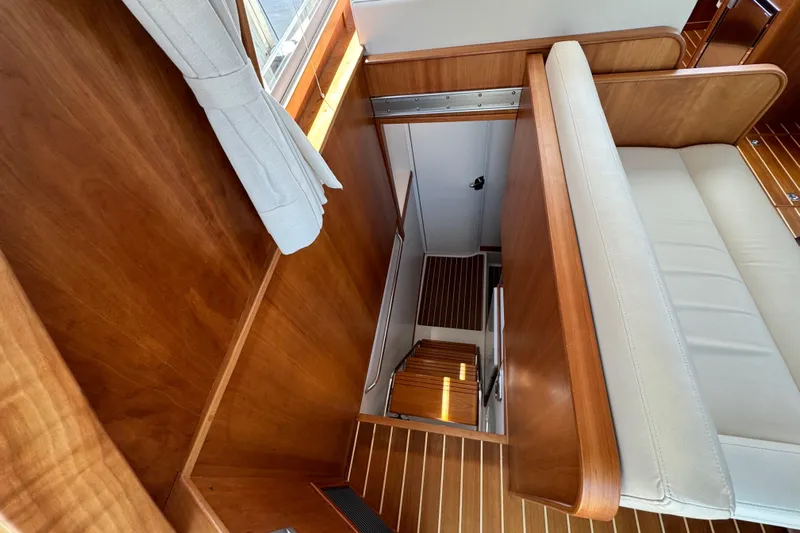 Moving On Yacht Photos Pics Interior view of 2022 Sabre 48 Salon Express, featuring wooden finishes and a staircase.