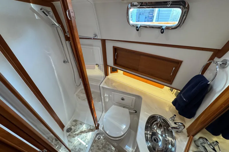 Moving On Yacht Photos Pics Luxurious bathroom in 2022 Sabre 48 Salon Express yacht with modern fixtures and wood accents.