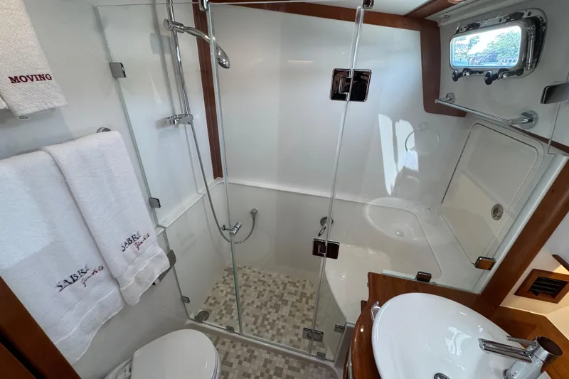 Moving On Yacht Photos Pics Luxurious bathroom in 2022 Sabre 48 Salon Express yacht with glass shower and elegant fixtures.