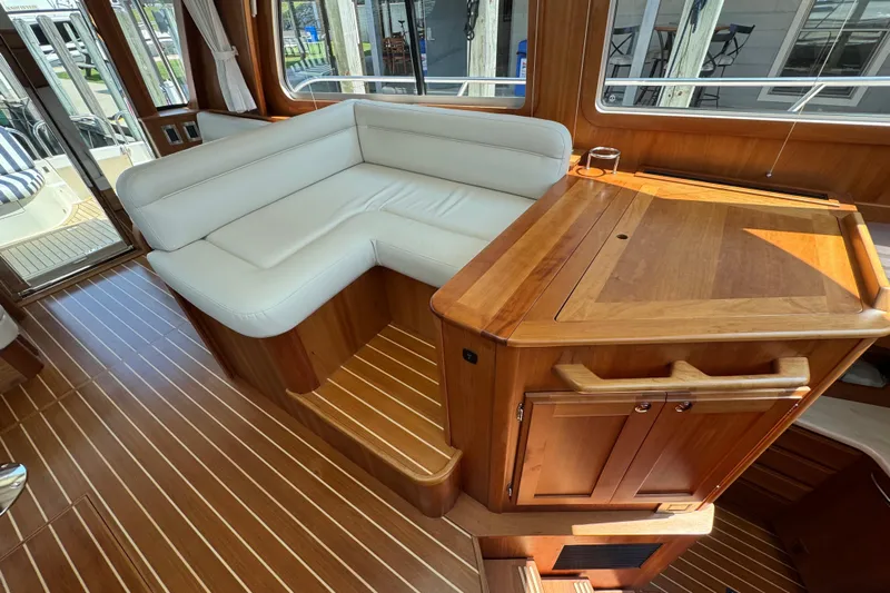 Moving On Yacht Photos Pics Interior of 2022 Sabre 48 Salon Express with white seating and wooden cabinetry.