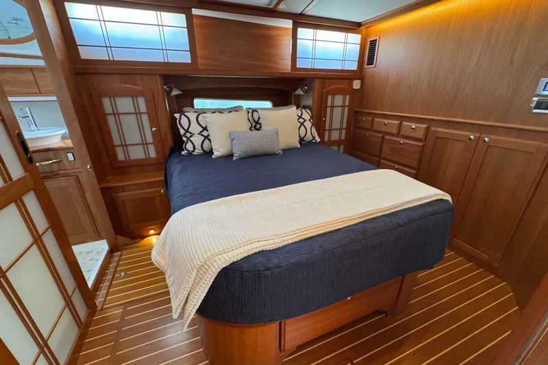 Moving On Yacht Photos Pics Luxurious bedroom interior of 2022 Sabre 48 Salon Express yacht with wood finish.