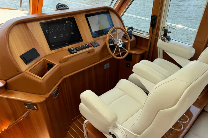 Moving On Yacht Photos Pics 2022 Sabre 48 Salon Express helm with leather seats and modern navigation displays.