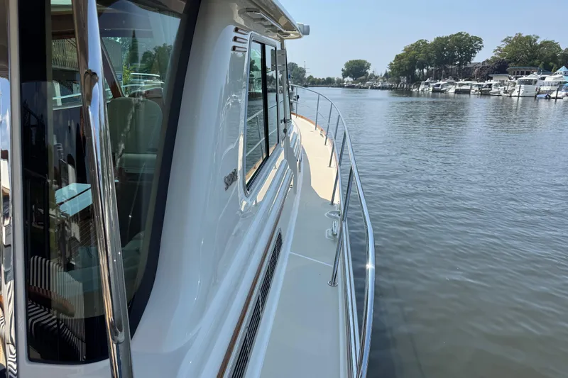 Moving On Yacht Photos Pics 2022 Sabre 48 Salon Express yacht on a calm river, showcasing sleek design and luxury.