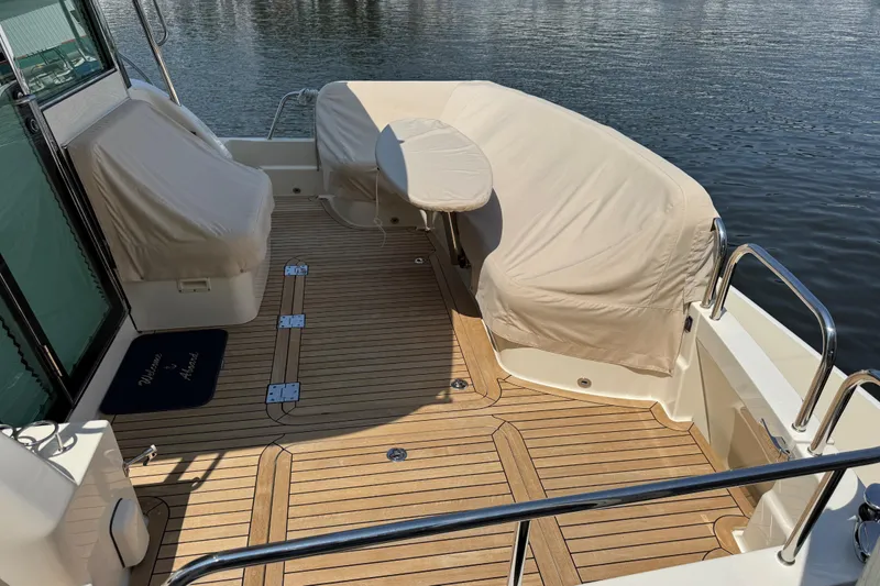 Moving On Yacht Photos Pics 2022 Sabre 48 Salon Express yacht deck with covered seating and wooden flooring.