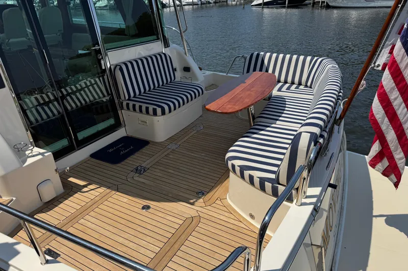 Moving On Yacht Photos Pics 2022 Sabre 48 Salon Express yacht with striped seating and wooden deck.