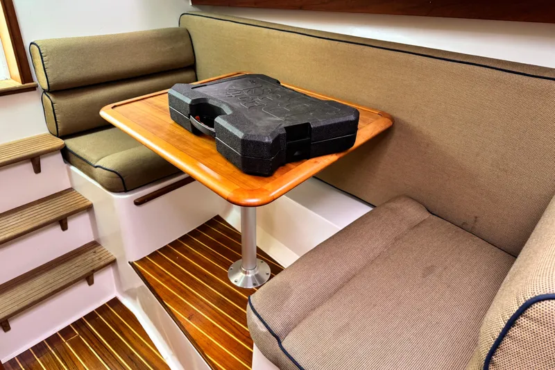 Pastis Yacht Photos Pics Cozy interior of 2005 Hunt SurfHunter with cushioned seating and wooden table.