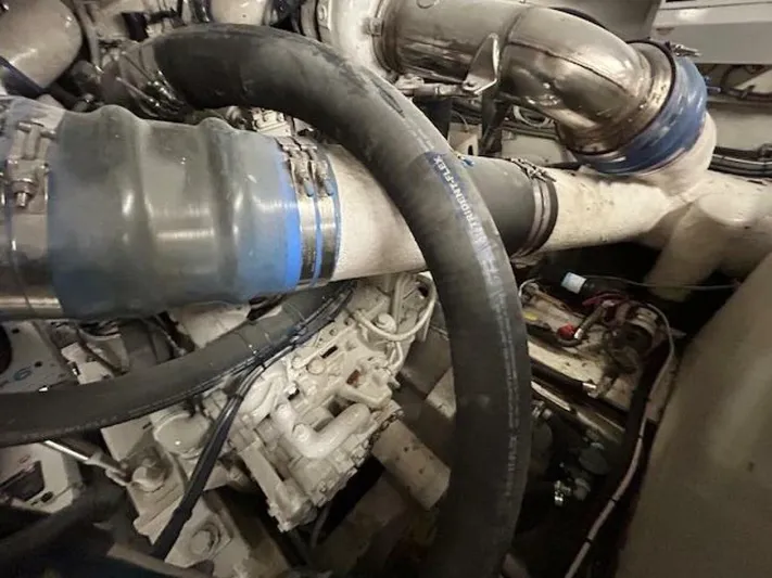 Code Vessel Yacht Photos Pics Engine room of 1989 Hatteras Convertible boat with visible hoses and pipes.