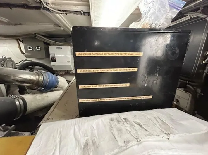 Code Vessel Yacht Photos Pics Engine room of 1989 Hatteras Convertible with labeled storage box and mechanical parts.