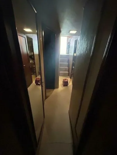 Code Vessel Yacht Photos Pics Narrow hallway inside 1989 Hatteras Convertible yacht with dim lighting.