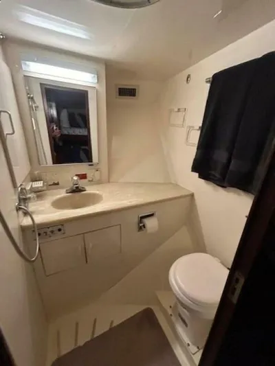 Code Vessel Yacht Photos Pics 1989 Hatteras Convertible yacht bathroom with sink, toilet, and mirror.