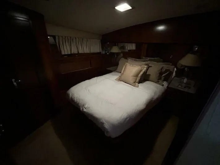 Code Vessel Yacht Photos Pics Cozy bedroom interior of 1989 Hatteras Convertible yacht with elegant wood paneling.
