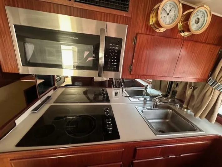 Code Vessel Yacht Photos Pics 1989 Hatteras Convertible yacht kitchen with microwave, stove, and dual sinks.