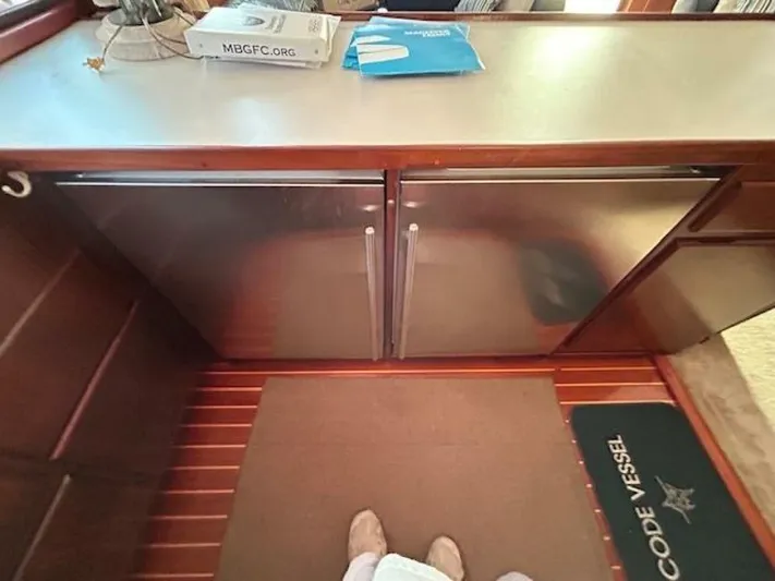 Code Vessel Yacht Photos Pics Interior of 1989 Hatteras Convertible yacht with stainless steel cabinets and wooden flooring.