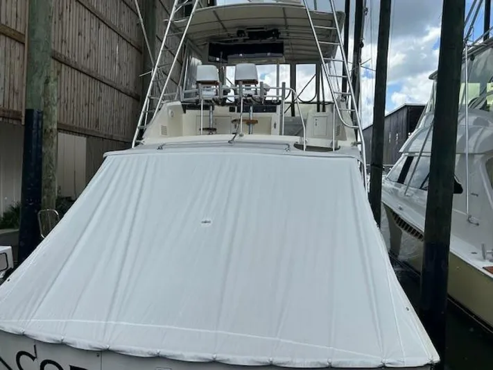 Code Vessel Yacht Photos Pics 1989 Hatteras Convertible yacht with covered deck, docked in marina.