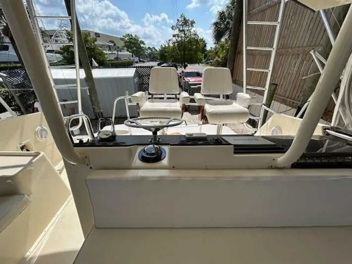 Code Vessel Yacht Photos Pics 1989 Hatteras Convertible boat interior with steering wheel and seating area.