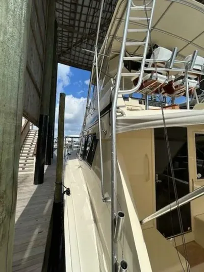 Code Vessel Yacht Photos Pics 1989 Hatteras Convertible yacht docked under a covered marina.