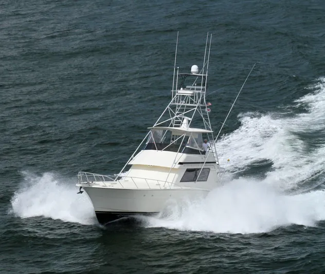 Code Vessel Yacht Photos Pics 1989 Hatteras Convertible yacht cruising swiftly on open water.