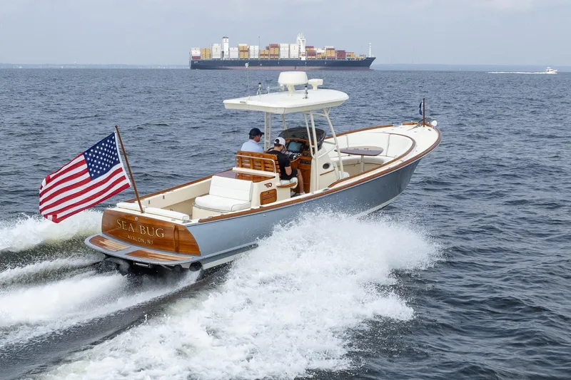 Sea Bug Yacht Photos Pics 2017 Hinckley Talaria 29C boat cruising with American flag, container ship in background.