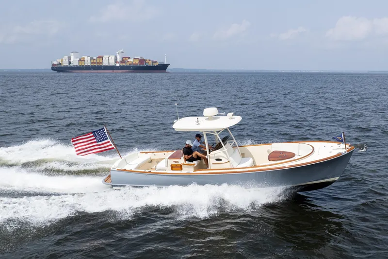 Sea Bug Yacht Photos Pics 2017 Hinckley Talaria 29C cruising with American flag, container ship in background.