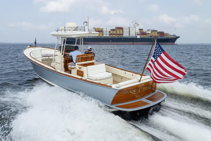Sea Bug Yacht Photos Pics 2017 Hinckley Talaria 29C cruising with American flag, container ship in background.
