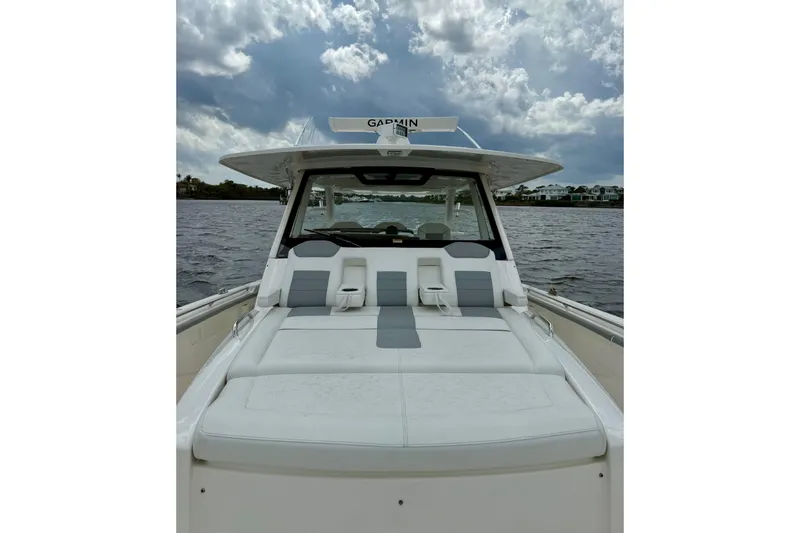 Seakeeper Yacht Photos Pics 2020 Pursuit S 408 Sport boat with cushioned seating on a cloudy day.
