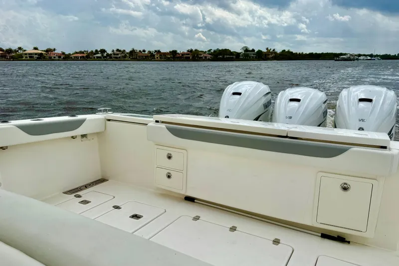 Seakeeper Yacht Photos Pics 2020 Pursuit S 408 Sport boat with triple Yamaha engines on a calm waterway.