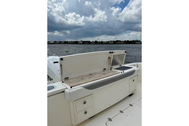 Seakeeper Yacht Photos Pics 2020 Pursuit S 408 Sport boat with open storage compartment on a cloudy day.