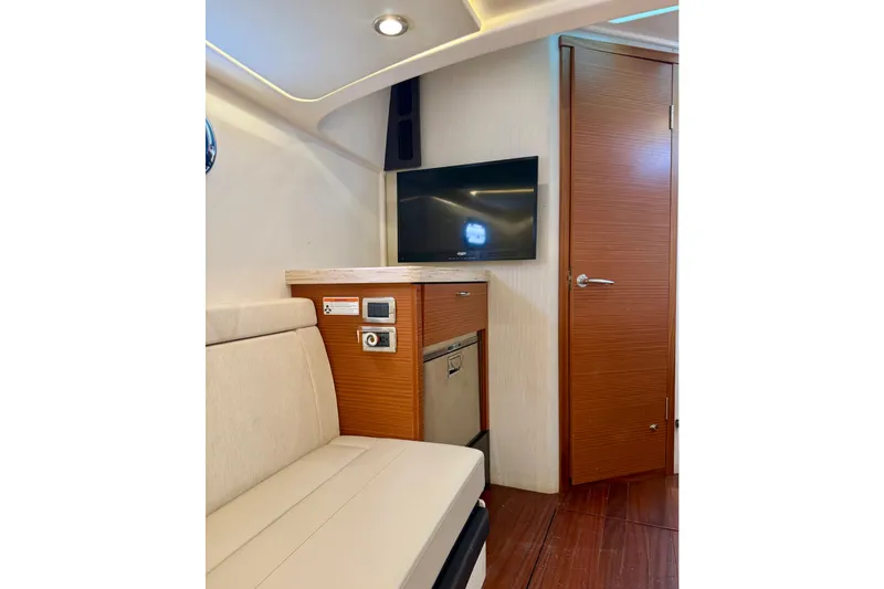 Seakeeper Yacht Photos Pics Interior of 2020 Pursuit S 408 Sport boat with TV, seating, and wooden cabinetry.