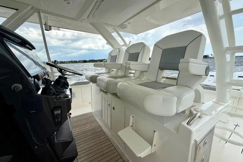 Seakeeper Yacht Photos Pics 2020 Pursuit S 408 Sport boat interior with helm and seating, overlooking water.