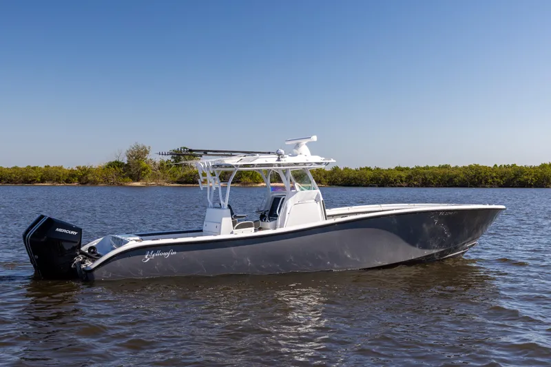 Bid Time 2 Yacht Photos Pics 2023 Yellowfin 36 Offshore boat on calm water, clear sky background.