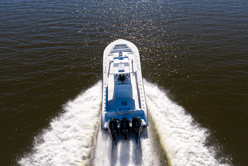 Bid Time 2 Yacht Photos Pics 2023 Yellowfin 36 Offshore boat cruising on open water, rear view.